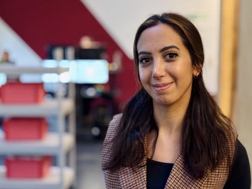 Porträt einer jungen Frau in einem modernen Bürosetting.