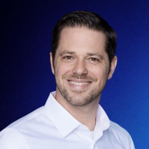 Porträt eines Mannes mit weißem Hemd vor blauem Hintergrund