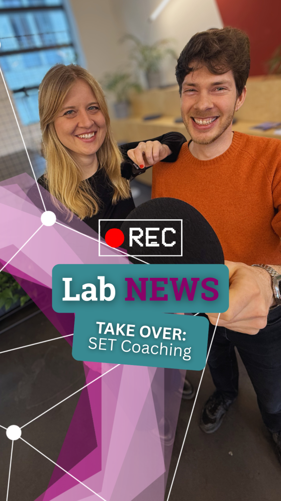 Zwei Personen sitzen nebeneinander, eine hält ein Mikrofon, im Vordergrund ein eingeblendetes rotes Aufnahme-Symbol und Textfelder mit 'Lab NEWS' und 'TAKE OVER: SET Coaching'