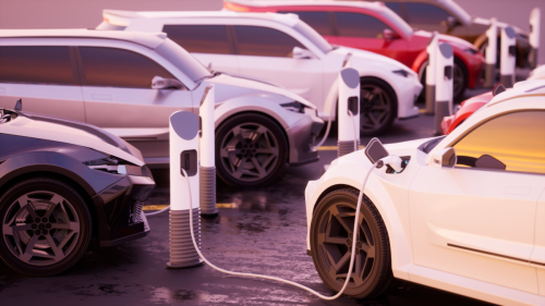 Mehrere Elektroautos stehen an Ladestationen, ein weißes Auto ist mit einem Ladekabel verbunden