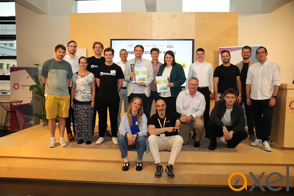 Gruppe von Menschen auf einer Bühne vor einer Leinwand mit dem Schriftzug 'ENERGY STARTUP PITCH'