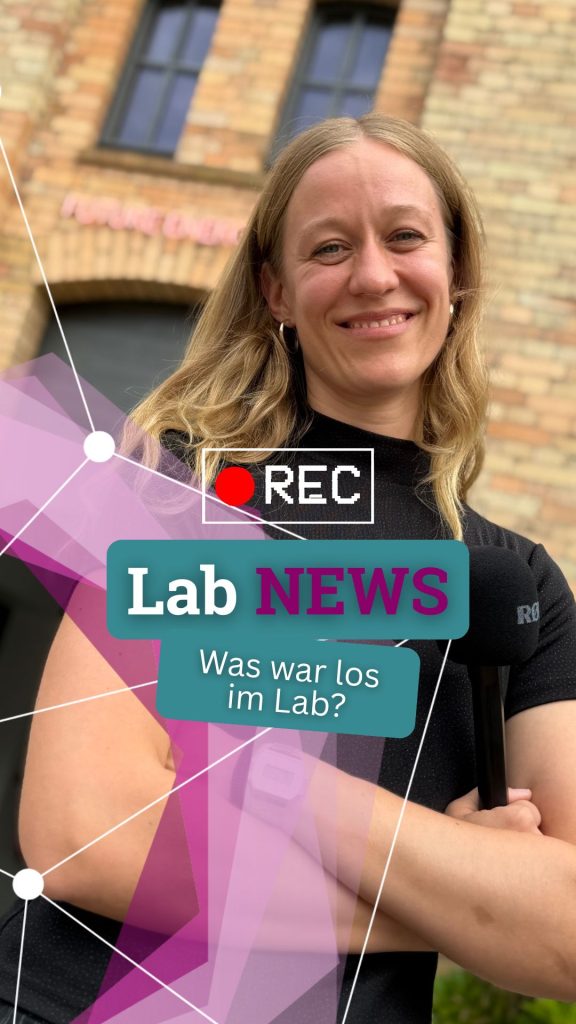 Lächelnde Frau mit langen blonden Haaren vor Backsteinmauer mit Fenster und Textfeldern 'Lab NEWS' und 'Was war los im Lab?'